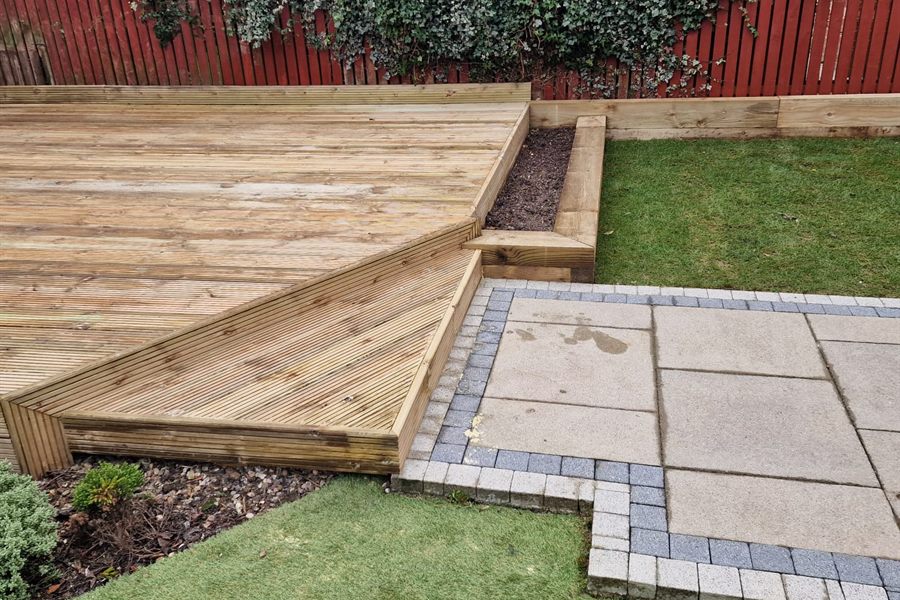 Decking stepping down to a slabbed path and new lawn