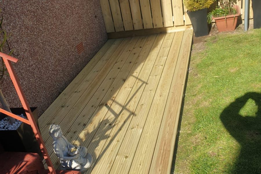 Narrow decking run along a house wall, new fence at the end