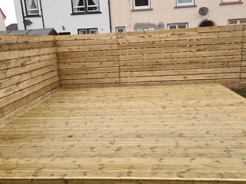 Timber decking inside a horizontal slat fence