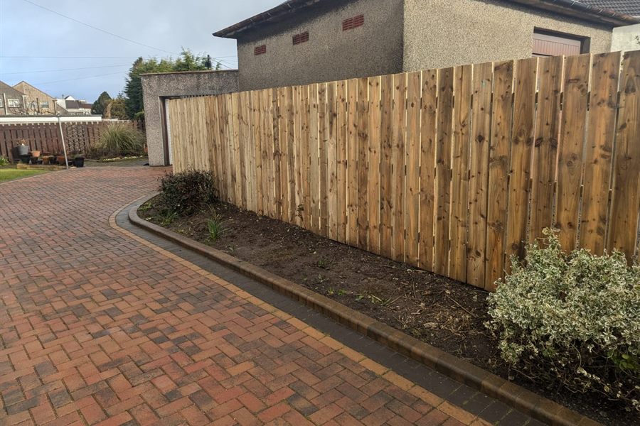 New close-board fence along a red monoblock drive