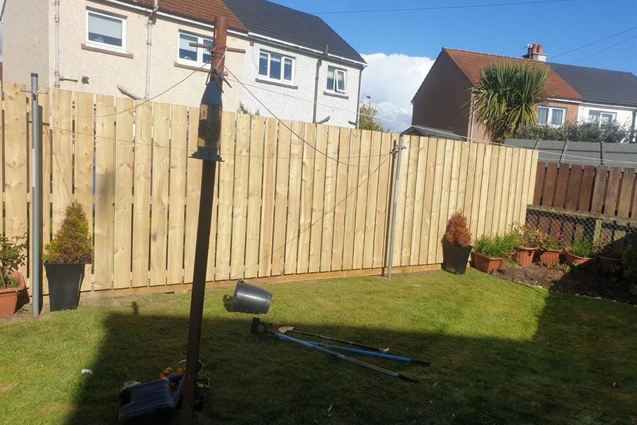 New fence round a lawn with pots along the bottom