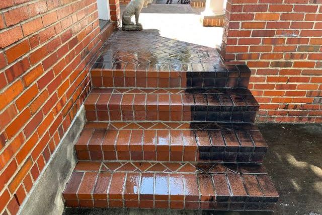 Brick steps being washed, a hard line between the cleaned brick and the dirt still to come off