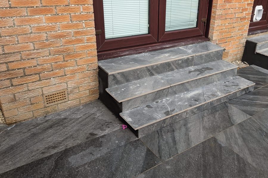 Dark porcelain steps and patio at a back door