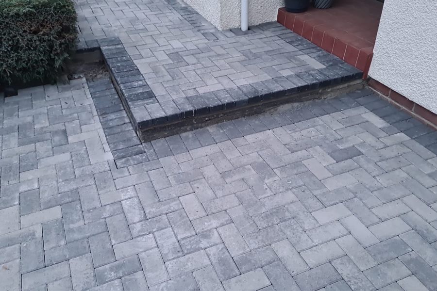 Grey herringbone monoblock with a charcoal border and raised step