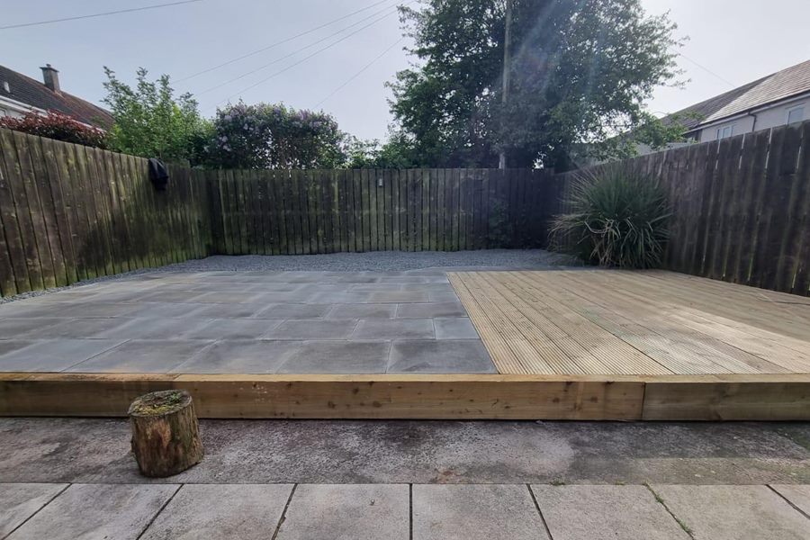 Raised slabbed patio with a sleeper edge and decking beside it