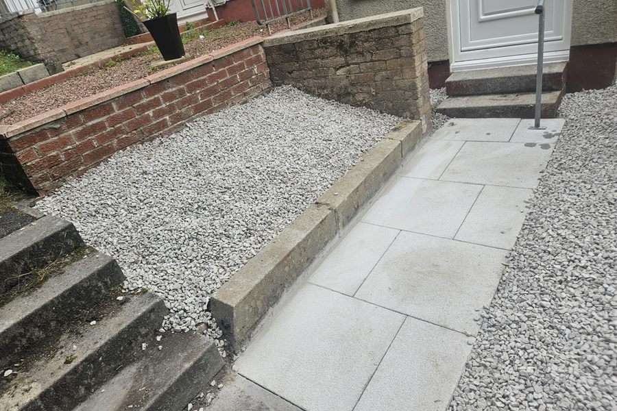 Slab path with a kerb, gravel bed and steps to a front door