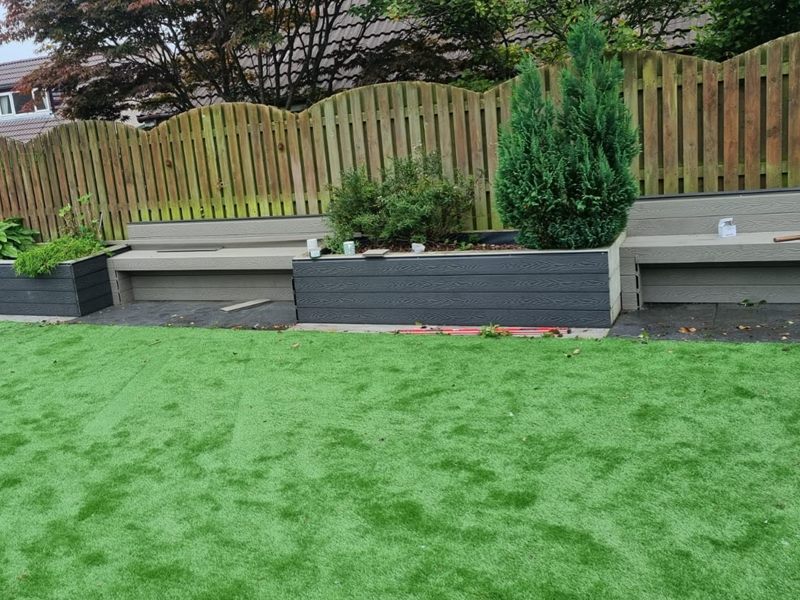Artificial lawn being edged against new composite planters