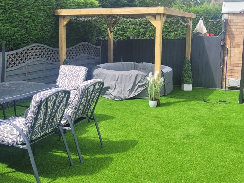Artificial lawn with garden furniture and a pergola
