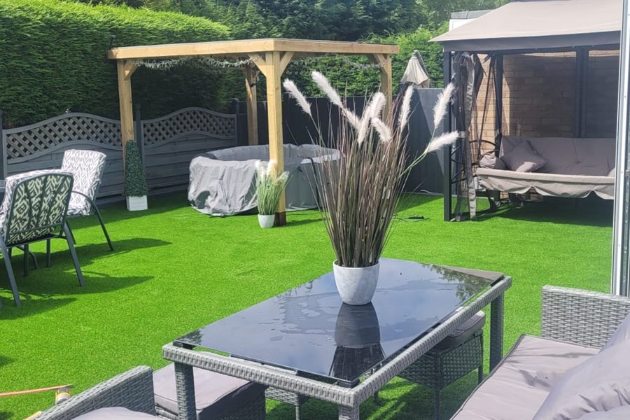 Artificial lawn with a table, pergola and swing seat