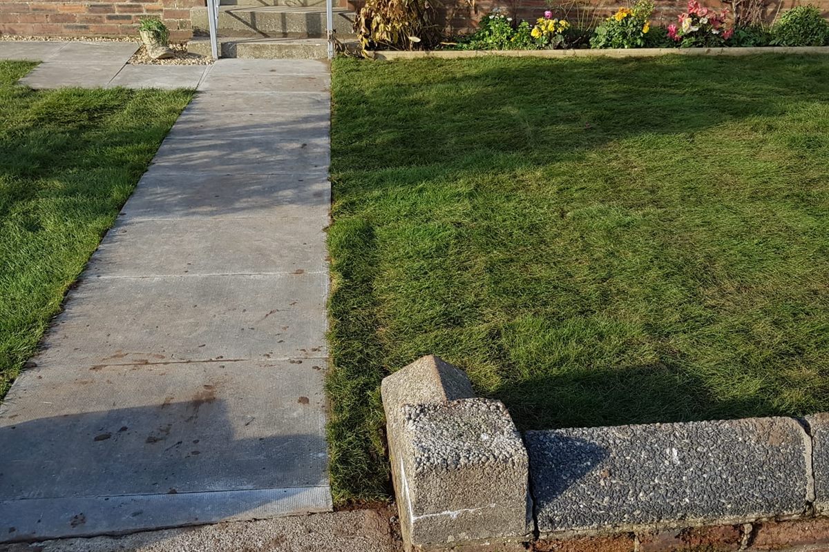 Fresh turf laid either side of a slab path to a front door