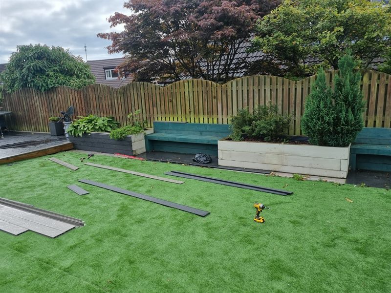 Artificial lawn being fitted with boards laid across it